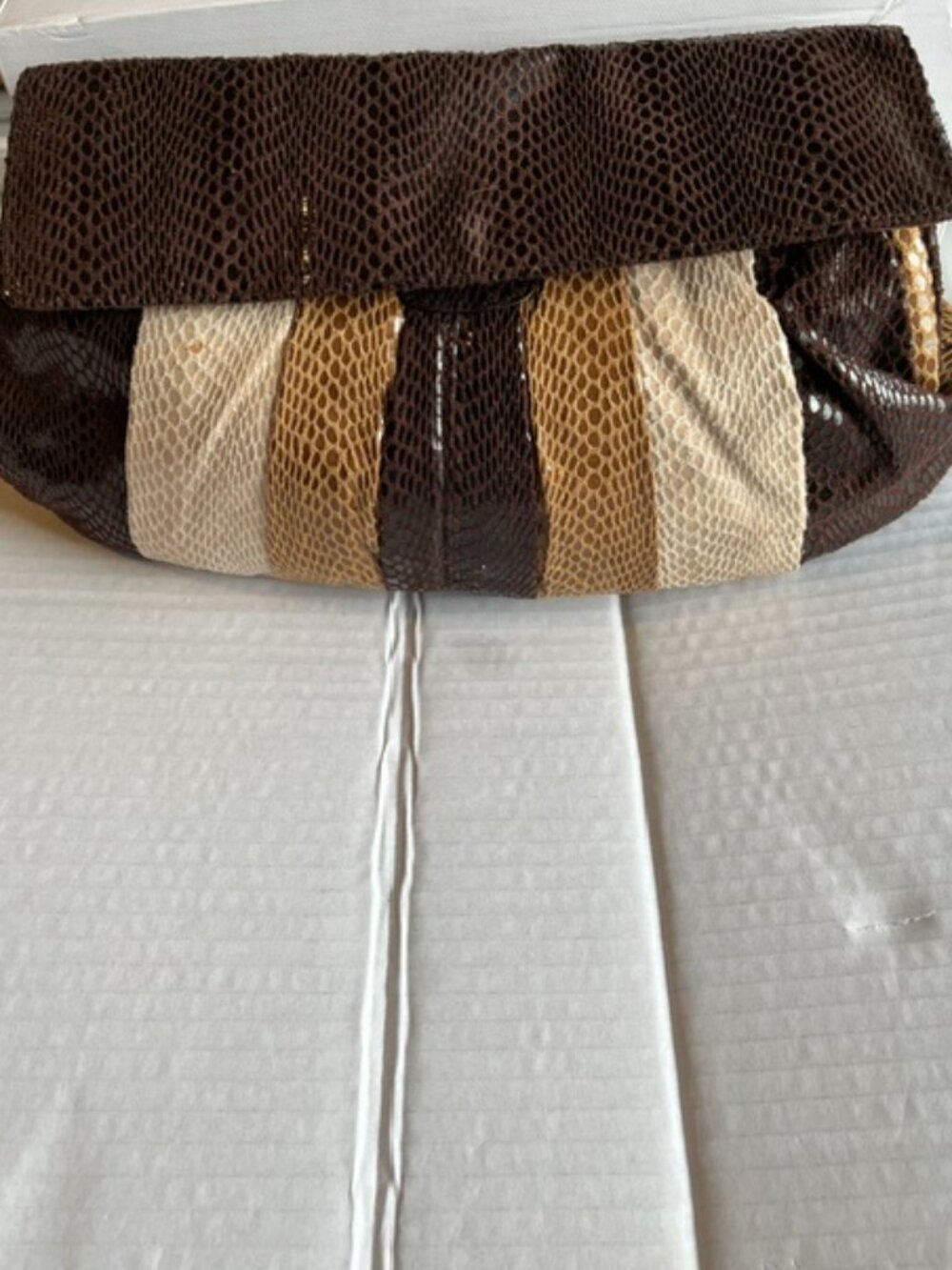 Faux snakeskin patchwork clutch.